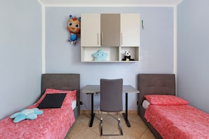 Ein Schlafzimmer mit zwei Betten, einem Schreibtisch und einem Kleiderschrank.