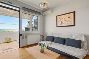 A modern living room with a sofa, a coffee table, and a painting on the wall.