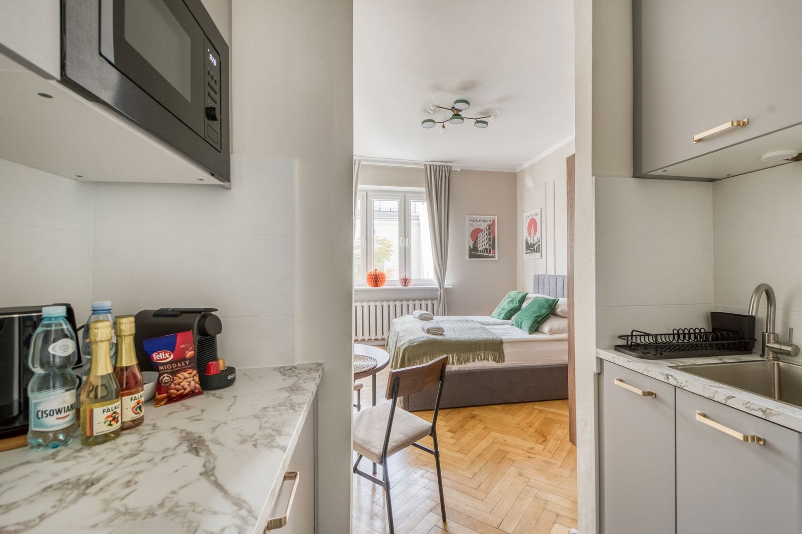 A compact kitchen with a microwave, a coffee machine, and various food items on the counter.
