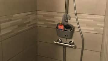 Una ducha con cabezal de ducha de mano y un accesorio de ducha manual.