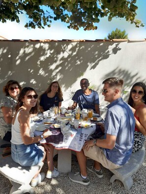 A group of people seated around a table with a menu, suggesting a dining setting. - BEACH HOUSE FOS (Fos-sur-Mer)