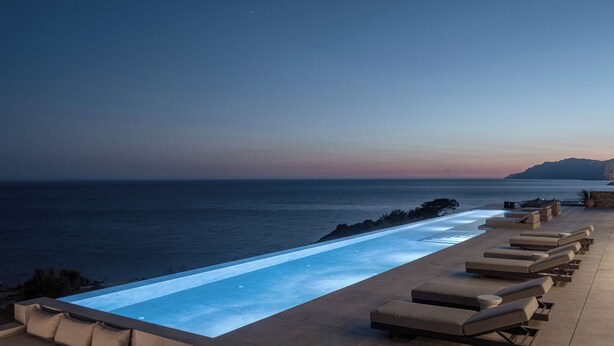 An infinity pool with lounge chairs, a view of the ocean, and a sunset. - Villa Aeterna - Exclusive 7-Bedroom Villa. Spectacular Sea Views & Total Privacy (Viannos)