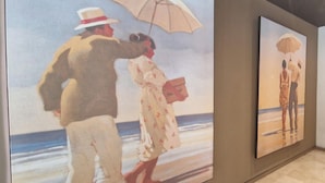 Un couloir orné de deux tableaux représentant des scènes de plage.