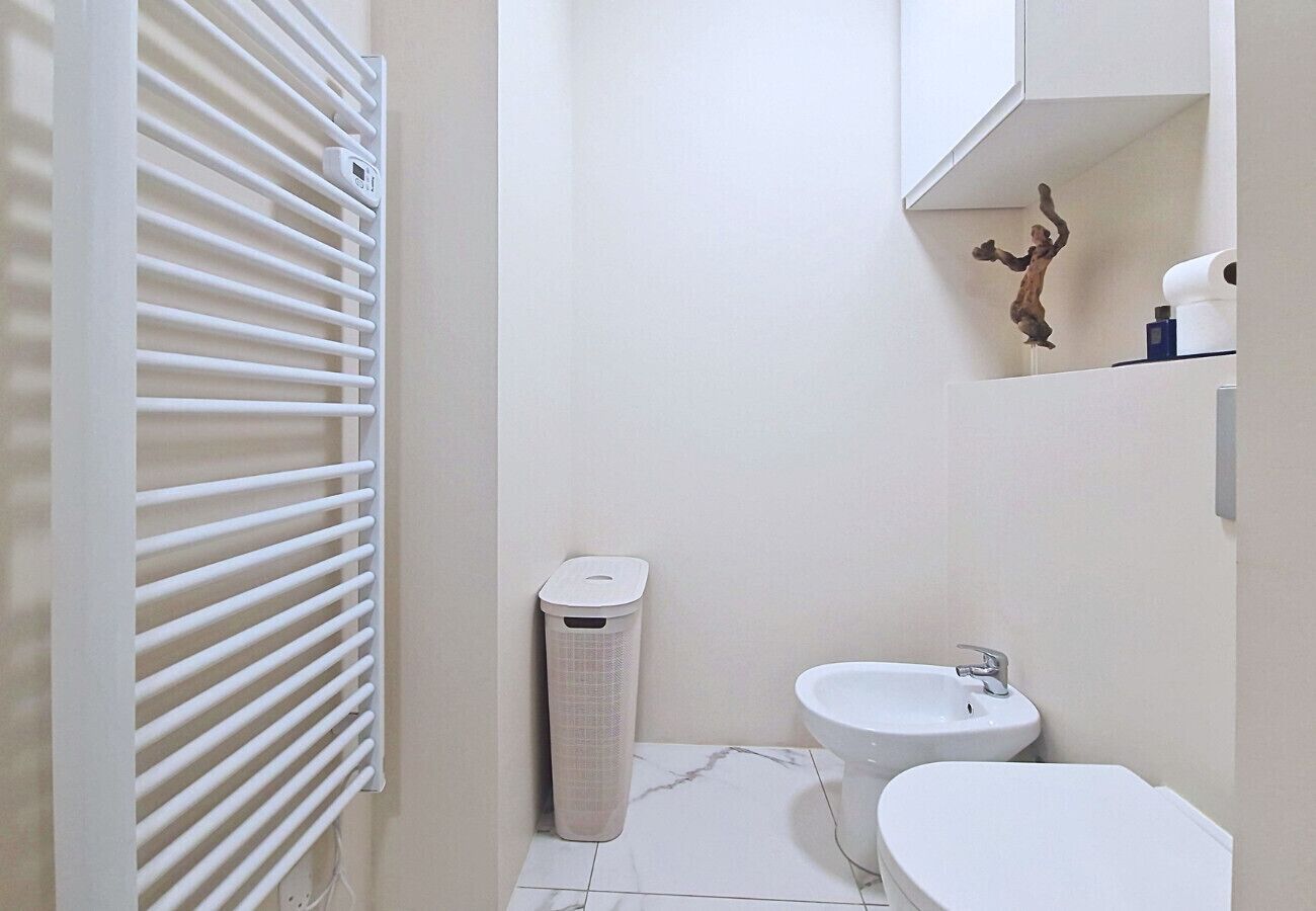 Een badkamer met een toilet, een bidet en een prullenbak.