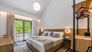 A modern hotel room with a large bed, a desk, and a chair. - Odat n`Bogë | Room 2 - Bjeshka | Breakfast Included by PikHost (Bogë)