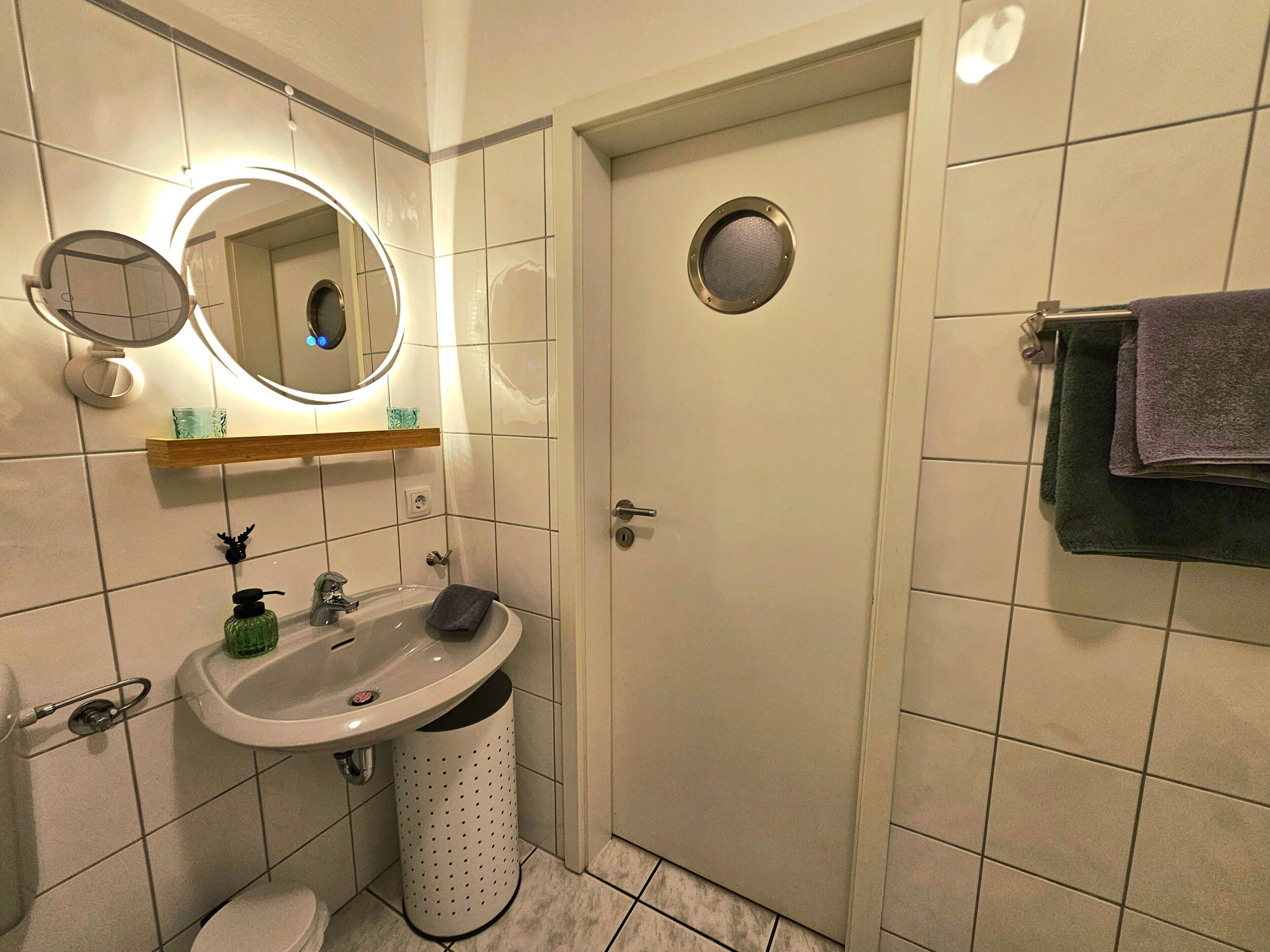 Une salle de bain avec un lavabo, un miroir et des toilettes.