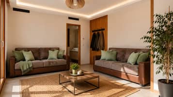 Un salon moderne avec deux canapés, une table basse et une plante en pot.