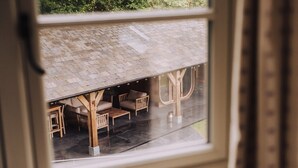 A covered outdoor seating area with wooden furniture and a tiled roof. - Moss Ghyll | Hot Tub, Sauna & Cinema Room (Windermere)