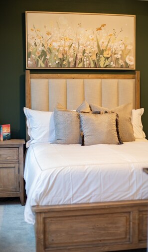 A bedroom with a bed, pillows, a nightstand, a book, and a painting on the wall. - Five-minute walk to downtown Atlanta with Rooftop (Atlanta)