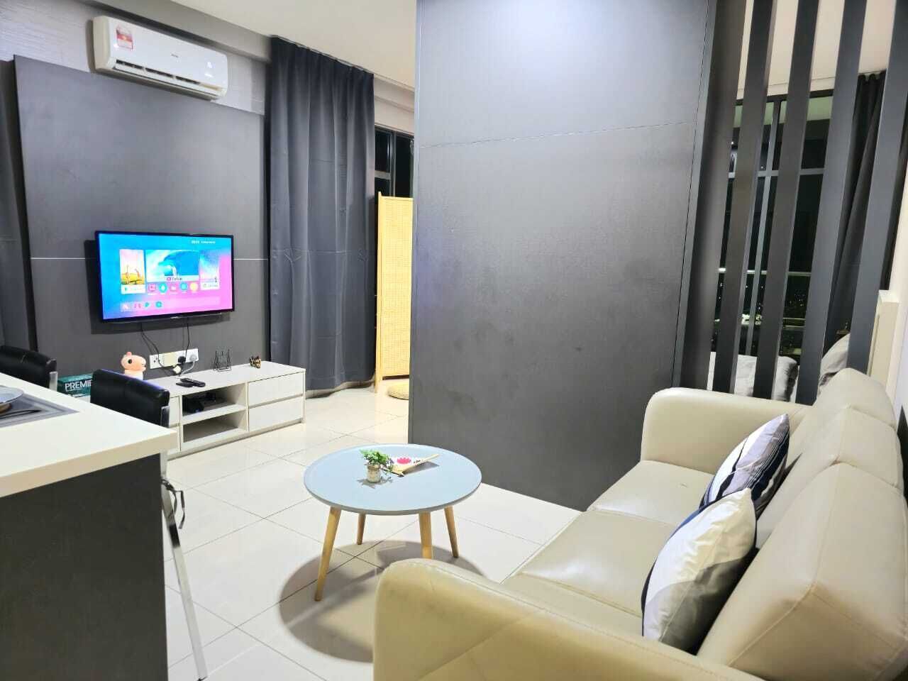 A modern living room with a sofa, a coffee table, a TV, and a white cabinet.