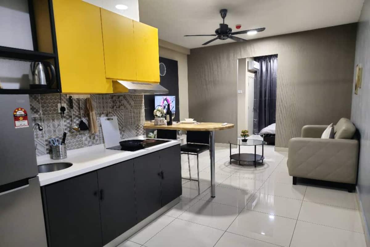 A modern kitchen with a dining area, a ceiling fan, and a sofa.