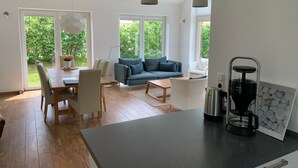 Un salon moderne avec un canapé, une table basse et un coin repas.