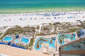 Ein Resort mit Strand, mehreren Schwimmbecken und einer Promenade.
