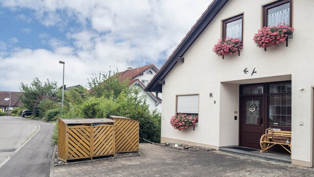 A building with a wooden gate, flower boxes, and a bench outside.