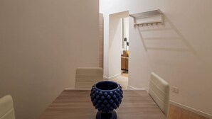 Un comedor con una mesa, sillas y un jarrón azul decorativo.