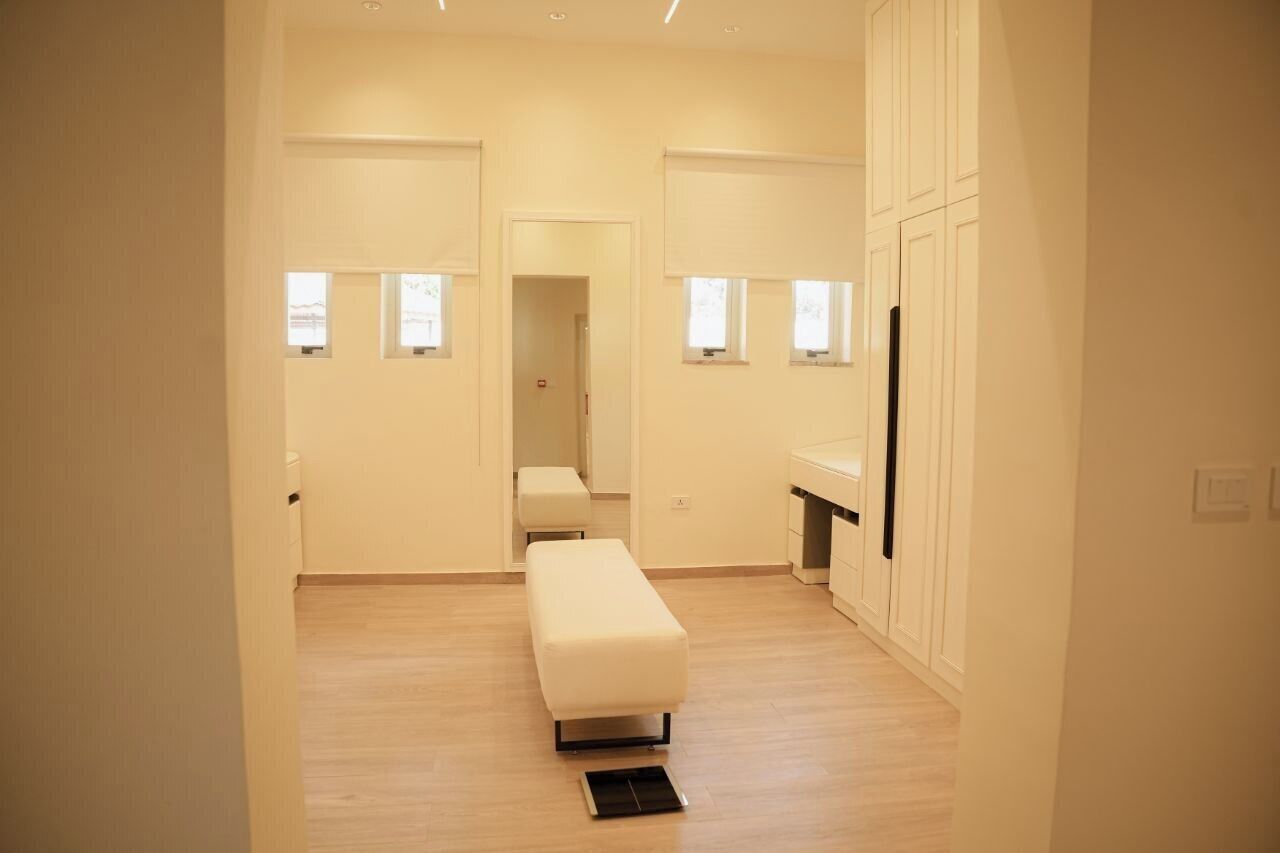 Una habitación amplia con un banco, una mesita y una ventana.