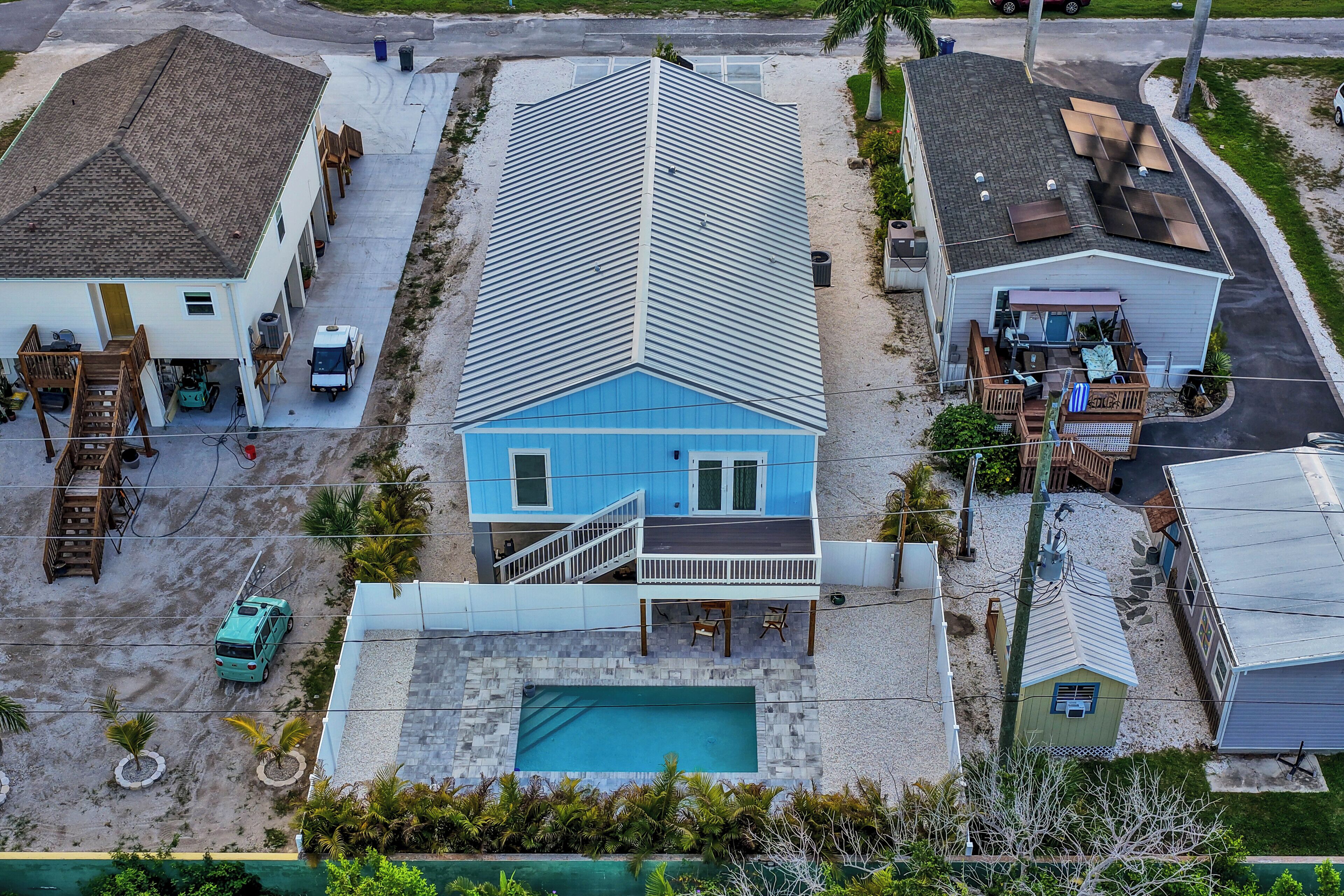 A two-story house with a swimming pool, a covered patio, and a garage.