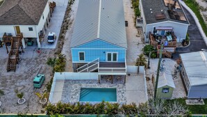 Una casa de dos pisos con piscina, patio cubierto y garaje.