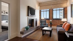 Ein modernes Wohnzimmer mit Kamin, Fernseher, Sofa und Couchtisch.