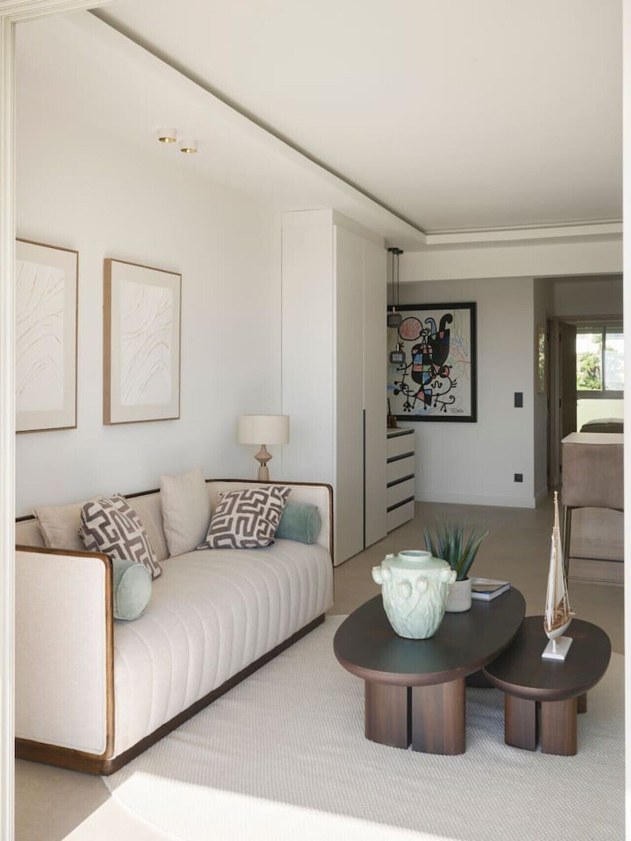 Un salon moderne avec un canapé, une table basse et un tableau accroché au mur.