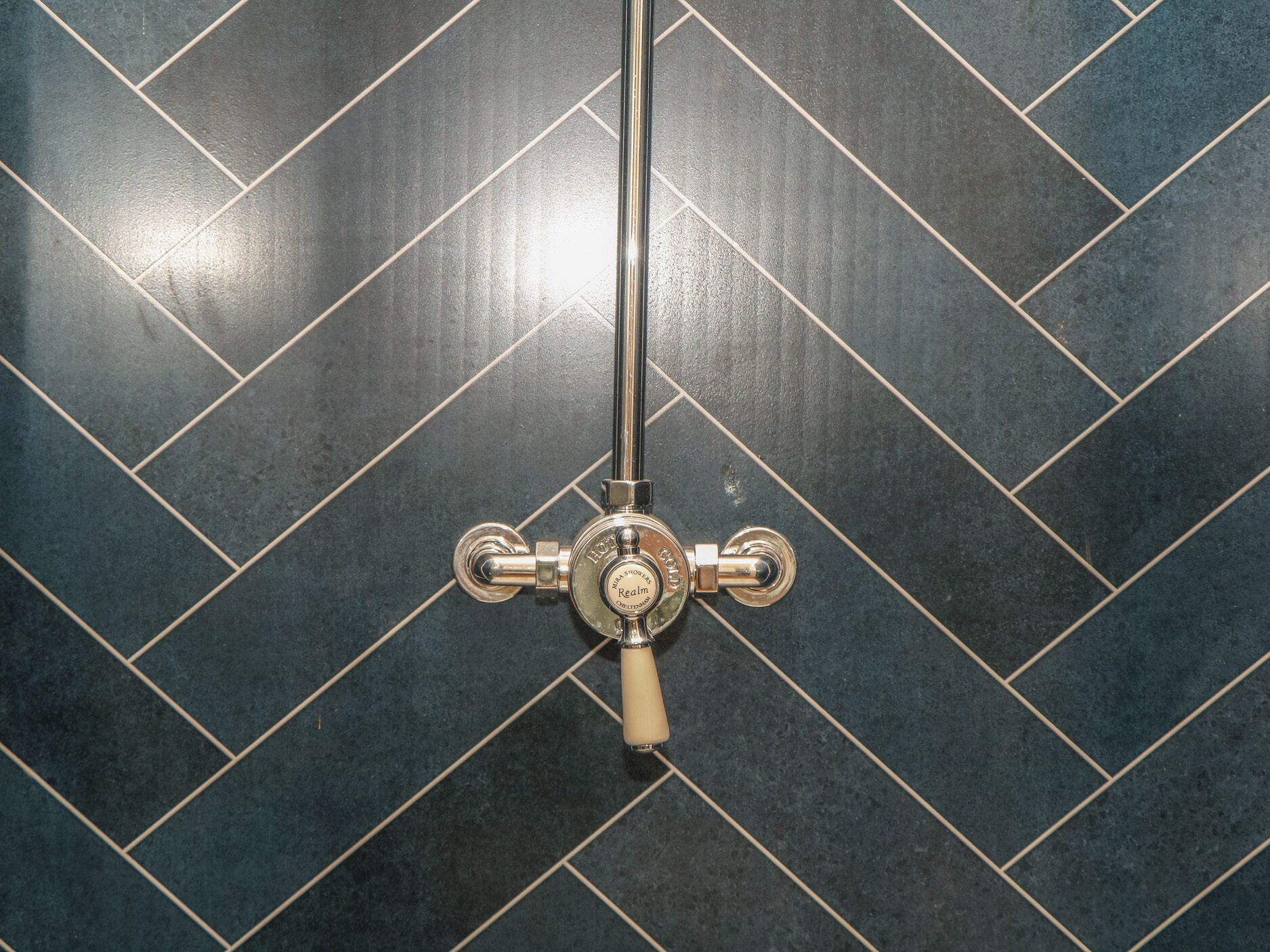A shower with a chrome faucet and a single-handle control.