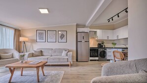 Een moderne woonkamer met een bank, salontafel en kunst aan de muur.