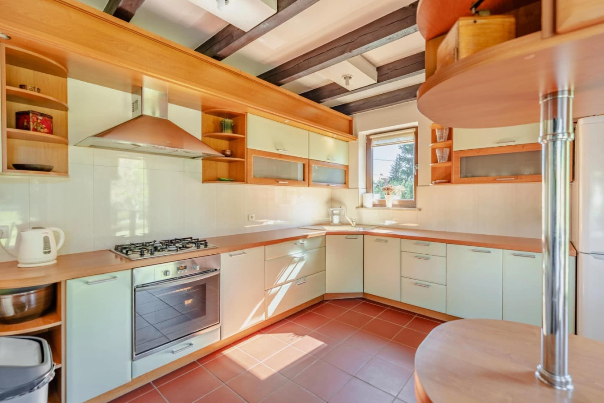 A modern kitchen with a gas stove, oven, and wooden cabinets.