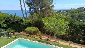 Una piscina con vistas al mar y vegetación circundante.