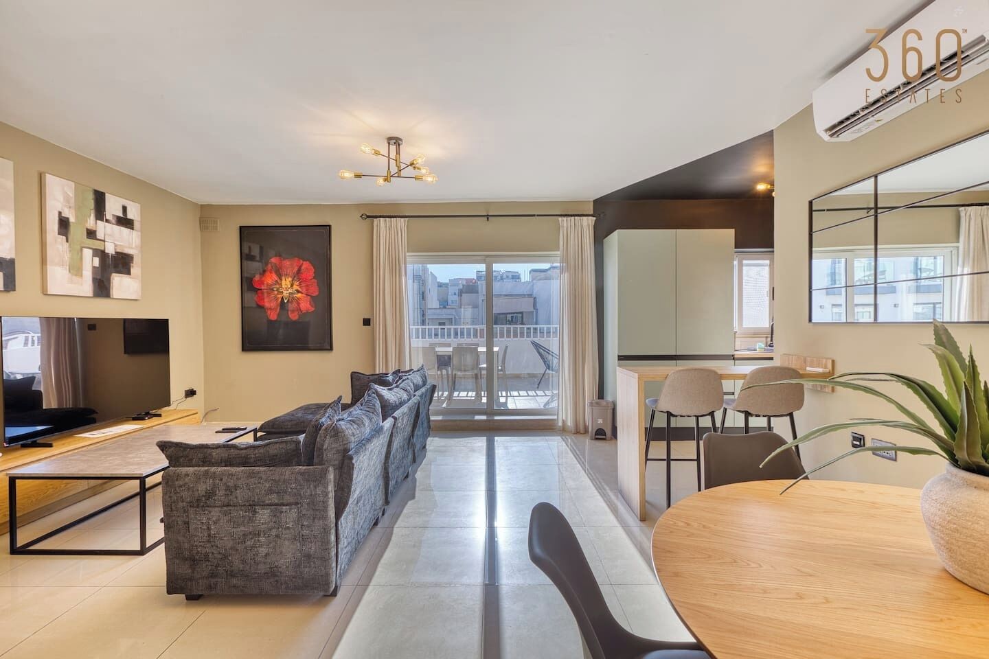 Un salon moderne avec un canapé, un téléviseur et un coin repas.