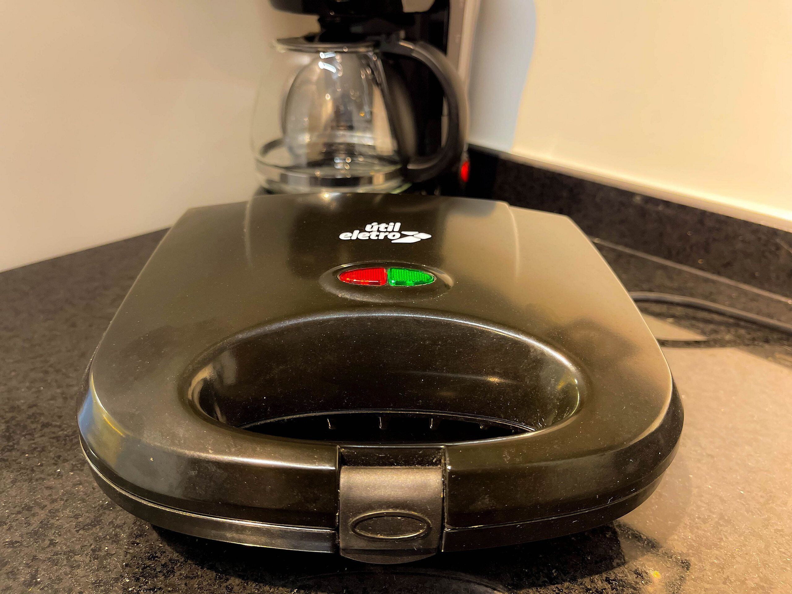 A portable electric kettle with a transparent lid, a power button, and a handle.