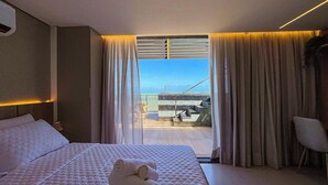Una habitación de hotel con cama, una silla y vista a la playa.