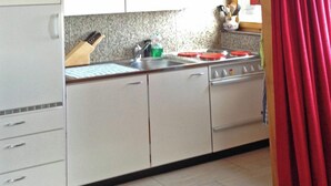 Une cuisine équipée d’une cuisinière, d’un évier et de placards.