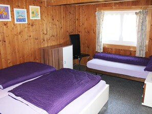 A room with two beds, a desk, a chair, and a window with curtains. - Ferienhaus Fäsch, (Flumserberg Bergheim), by Interhome (Flumserberg Bergheim)