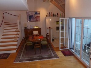 A dining area with a wooden table and chairs, a rug, a staircase, and a glass door leading outside. - Haus Gaschür, (Bad Ragaz), by Interhome (Bad Ragaz)