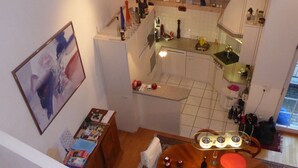 Una cucina con zona pranzo, un quadro appeso al muro e un tavolo con diversi oggetti.