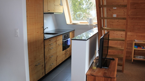 Een keuken met houten kastjes, een spoelbak en een raam.
