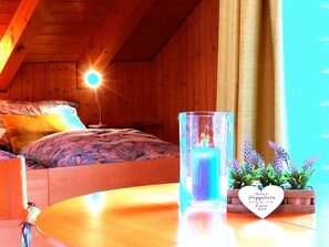 A cozy bedroom with a bed, a bedside table with a candle, and a decorative box with a message. - Schwendihof, (Flumserberg Tannenheim), by Interhome (Flumserberg Tannenheim)