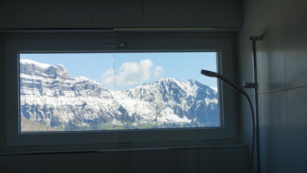 Ett fönster med utsikt över snöklädda berg.