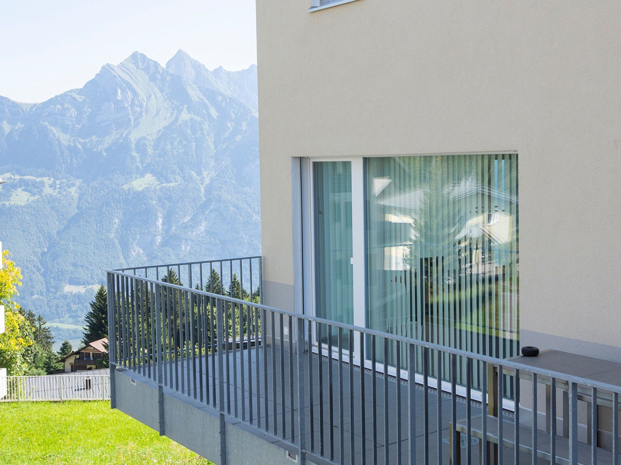 Un bâtiment moderne doté d’un balcon donnant sur un paysage montagneux.