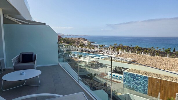 Un balcon avec vue sur la plage et l’espace piscine.