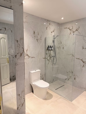 Habitación cuádruple familiar | Baño | Regadera, toallas, jabón, shampoo