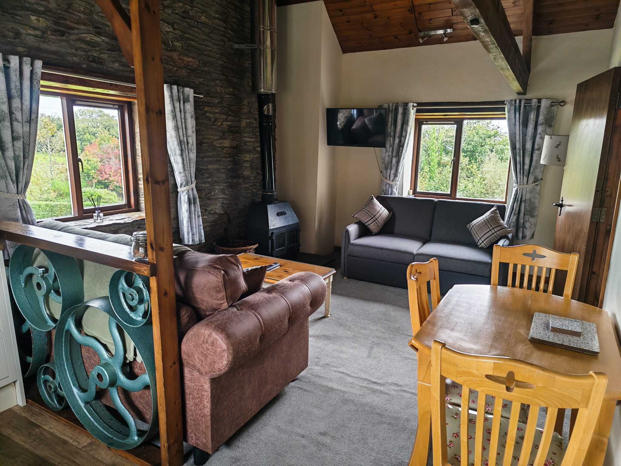 Treetop View at Old Mill Cottages, North Devon – characterful open-plan living and dining area with double sofa bed sleeping 2 guests, with fresh bedding and towels provided.