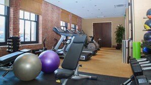 Ein Fitnessstudio mit Laufbändern, Gymbällen und Krafttrainingsgeräten.