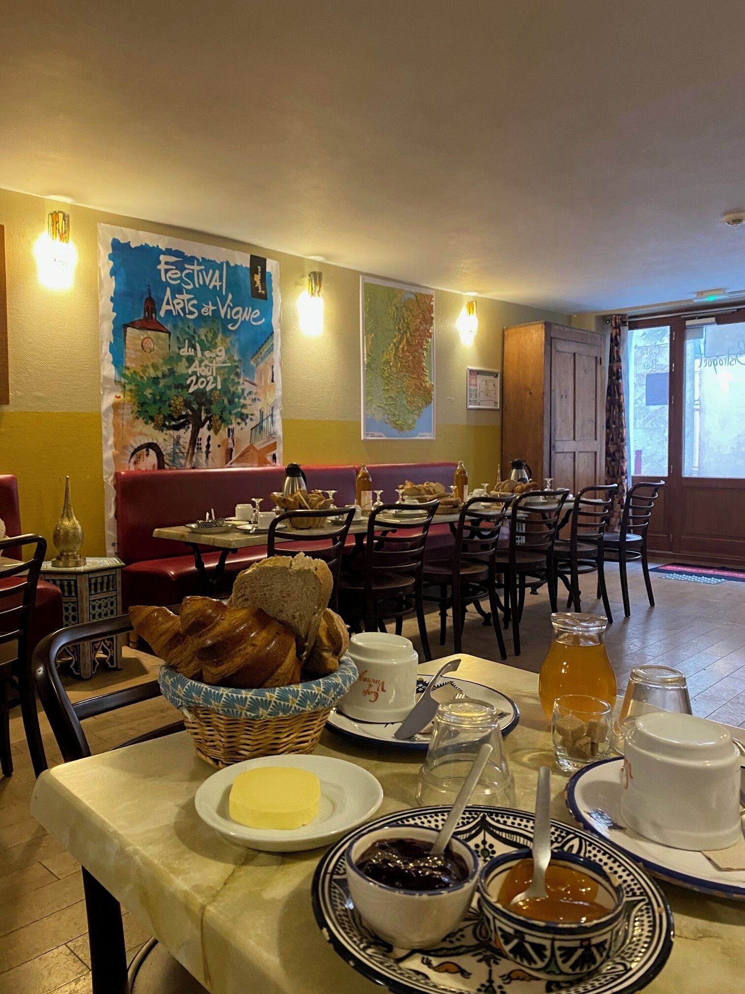 A dining area with tables, chairs, and a buffet with bread and condiments.
