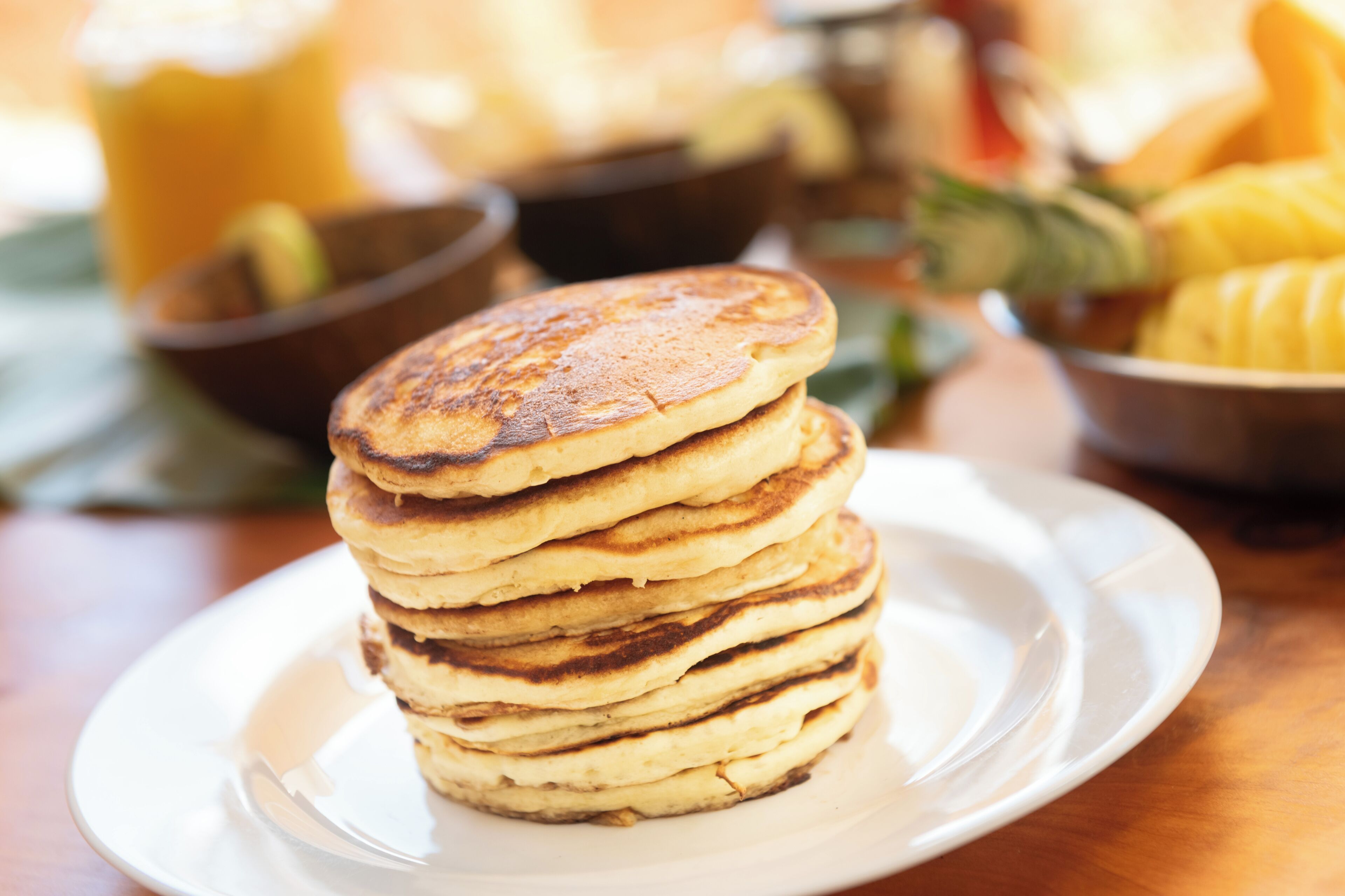 Una pila de tortitas sobre un plato blanco.