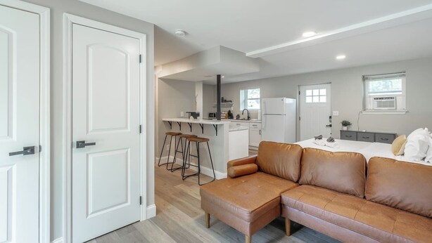 Een moderne keuken met witte kasten, een centraal eiland en barstoelen.