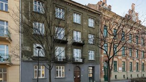 A multi-story building with a flat facade, multiple windows, and a door. - L23 Boutique 18B | City Center (Kraków)