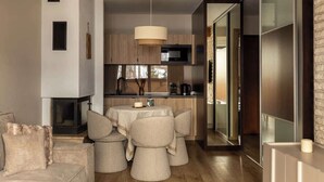 A modern kitchen with a central island, wooden cabinets, and a hanging light fixture. - Butorowy Residence | Sauna & Gym | Mountain View (Kościelisko)