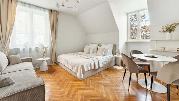 Une chambre à coucher moderne comprenant un lit, un canapé, une table à manger avec des chaises et une petite table d’appoint.