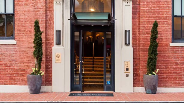 A hotel entrance with a sign reading 'D GHIRARDELLIC,' a double door entrance, and two potted plants on either side. - Wonderful 2-bedroom apartment with AC in San Francisco (San Francisco)